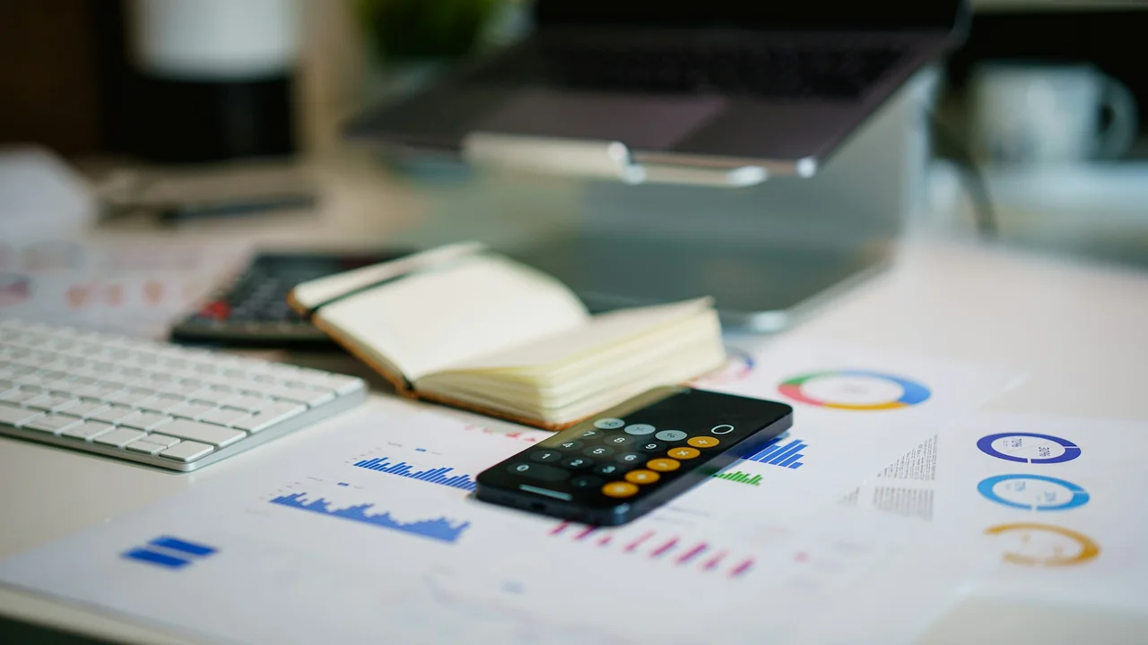 office desk with smartphone and financial charts