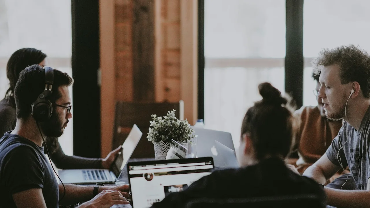 selective focus photography of people sits in front of table inside room
