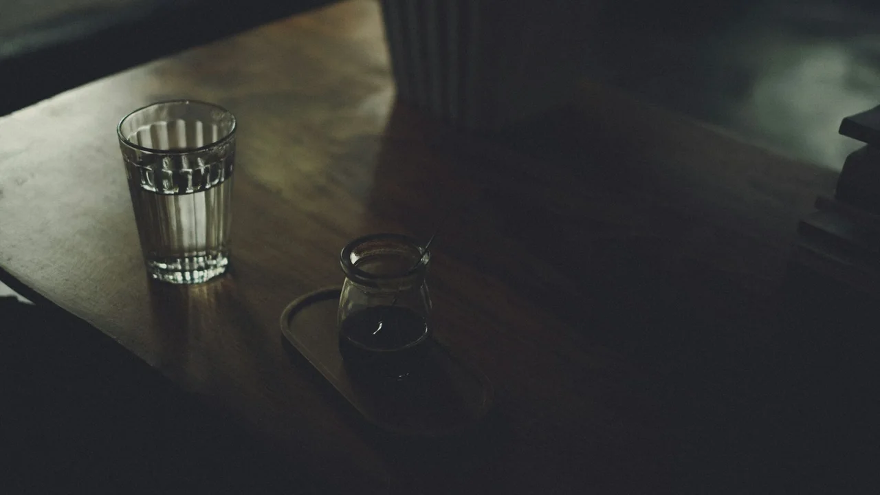 A glass of water sitting on top of a wooden table