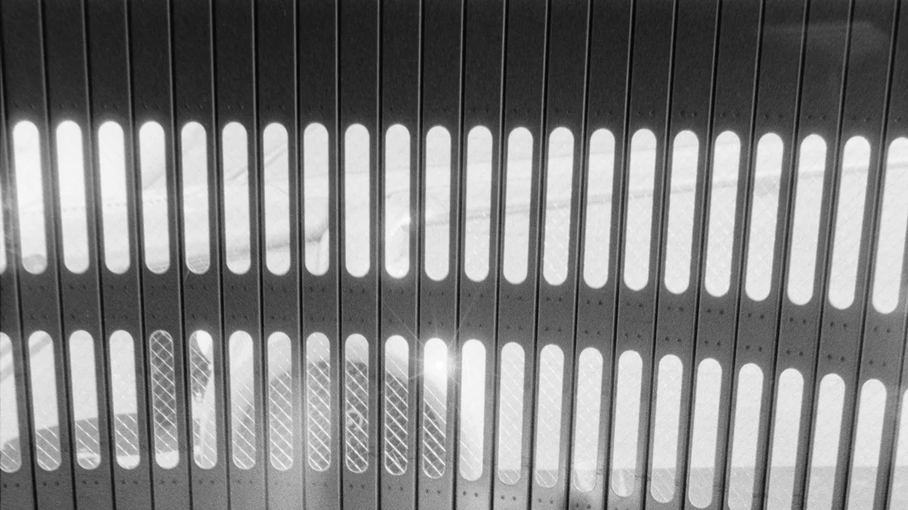 Luggage waits in a hallway with striped light patterns